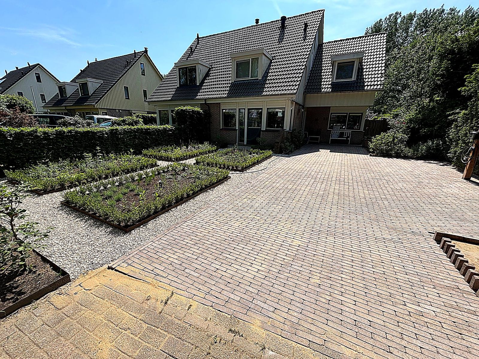 Formele voortuin met buxusparterres en oprit, aangelegd door Roks Tuinen